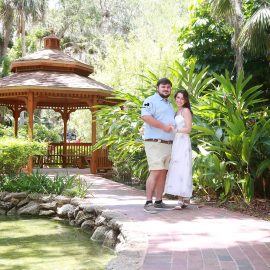 Palm Coast engagement portraits of a couple sharing an intimate moment in a beautiful outdoor park setting.
