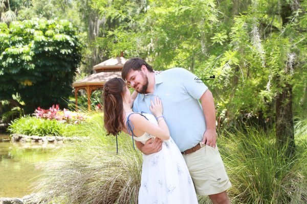Palm Coast engagement portraits of a couple sharing an intimate moment in a beautiful outdoor park setting.