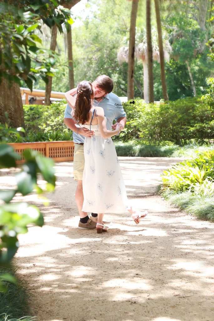Palm Coast engagement portraits of a couple sharing an intimate moment in a beautiful outdoor park setting.