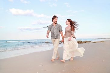 Romantic engagement photography session in Palm Coast, Florida, featuring a couple embracing outdoors in natural light.