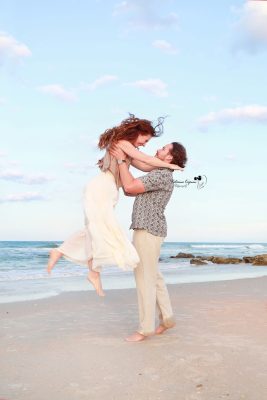 Romantic engagement photography session in Palm Coast, Florida, featuring a couple embracing outdoors in natural light.