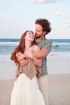 Romantic engagement photography session in Palm Coast, Florida, featuring a couple embracing outdoors in natural light.