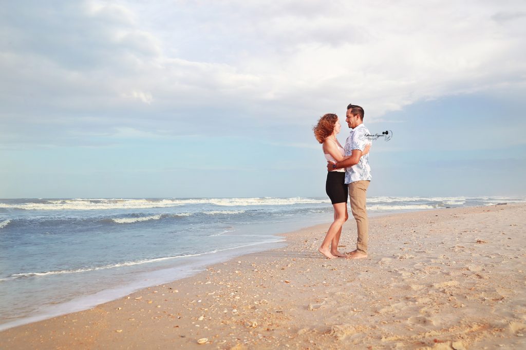 Engaged couple on the beach at Washington Oaks Gardens.