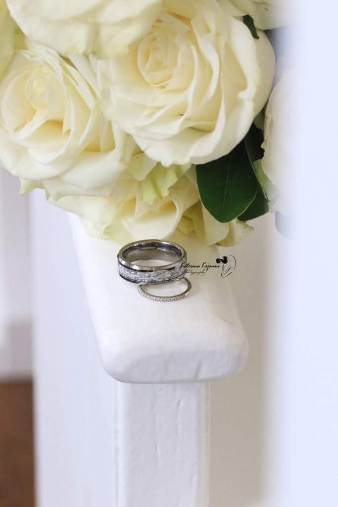 Close-up wedding photography of a bridal bouquet and wedding rings, capturing the elegant details of the wedding day.