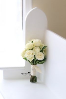 Close-up wedding photography of a bridal bouquet and wedding rings, capturing the elegant details of the wedding day.