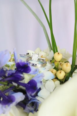 Close-up wedding photography of a bridal bouquet and wedding rings, capturing the elegant details of the wedding day.